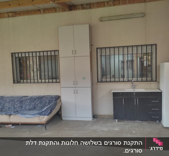 שני חלונות עם סורגים על קיר חיצוני